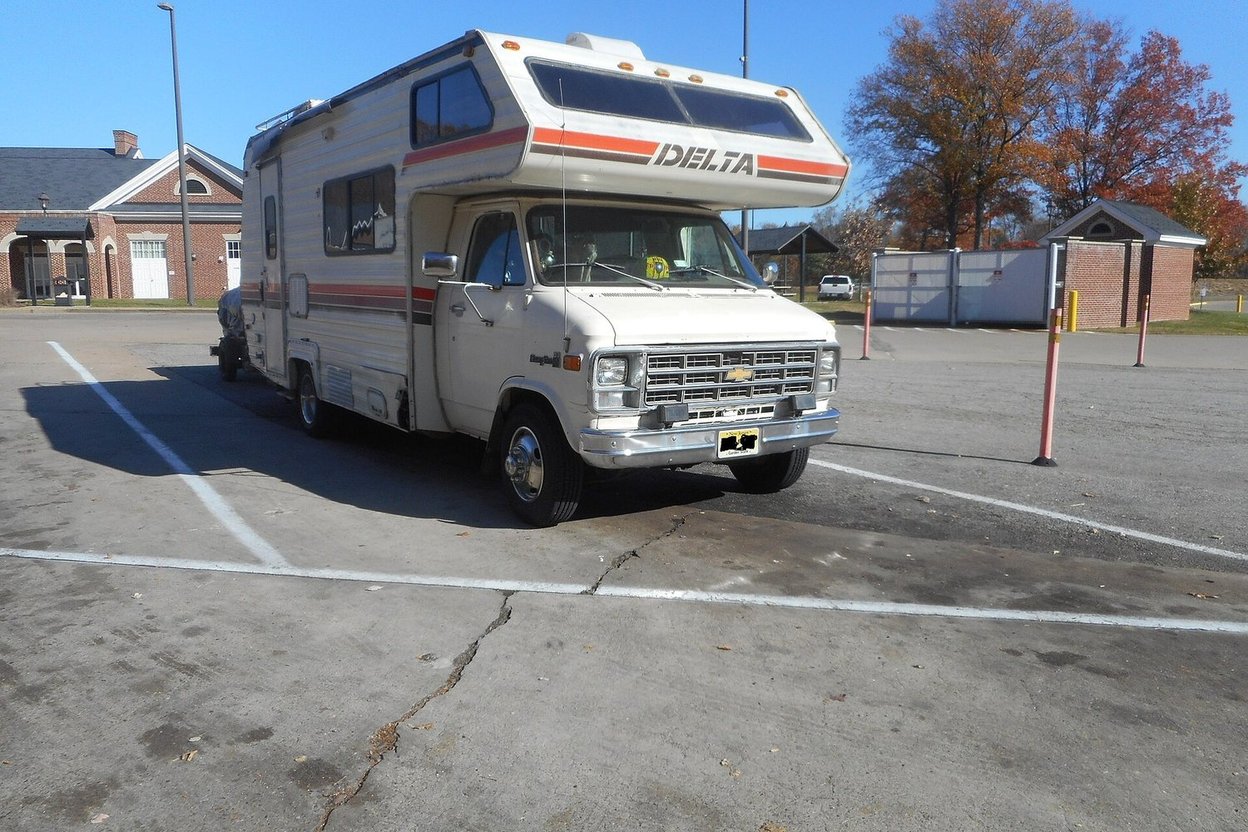 An older Class C motorhome parked in a lot