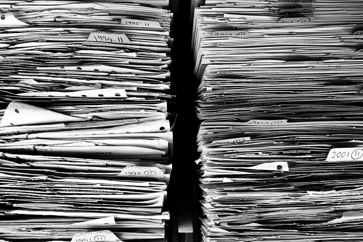 A stack of vehicle title paperwork on a desk
