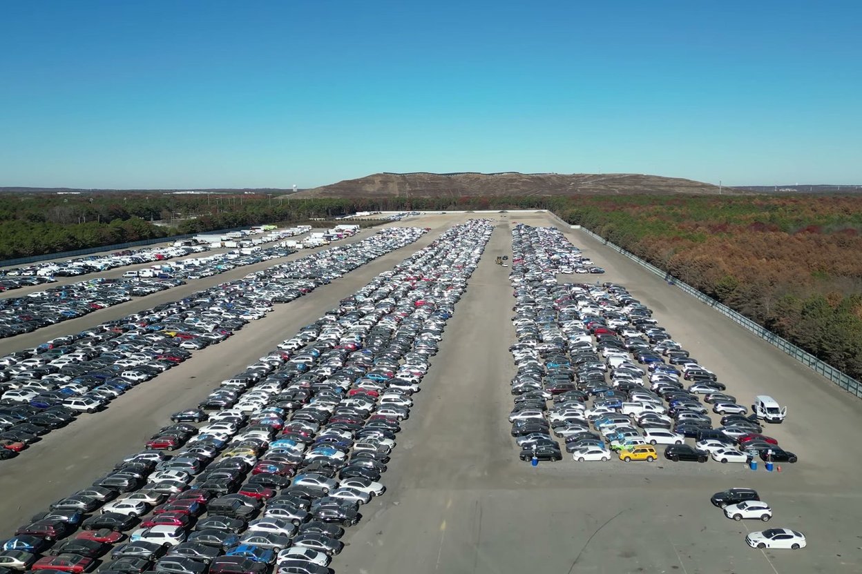 Drone view of thousands of vehicles in long rows at a Copart yard on Long Island, New York