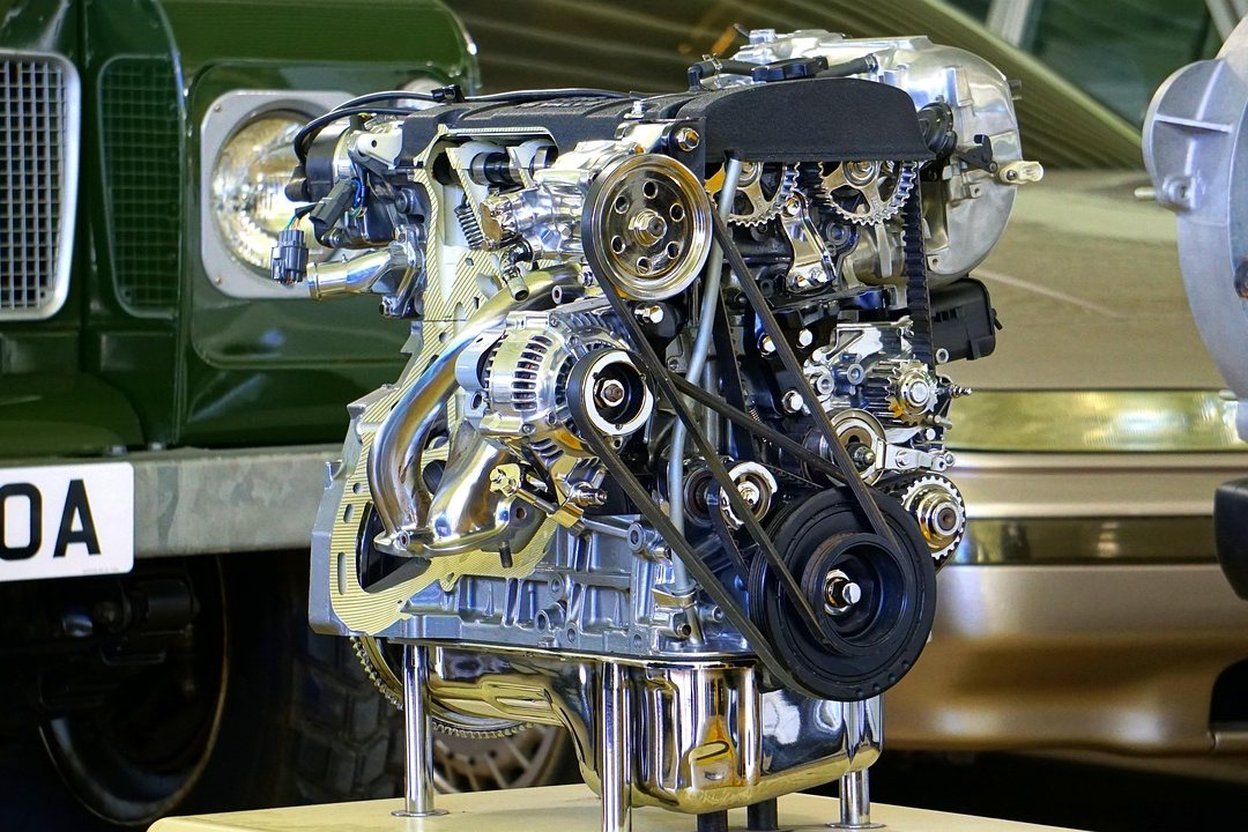 An engine being pulled from a wrecked car with a shop hoist